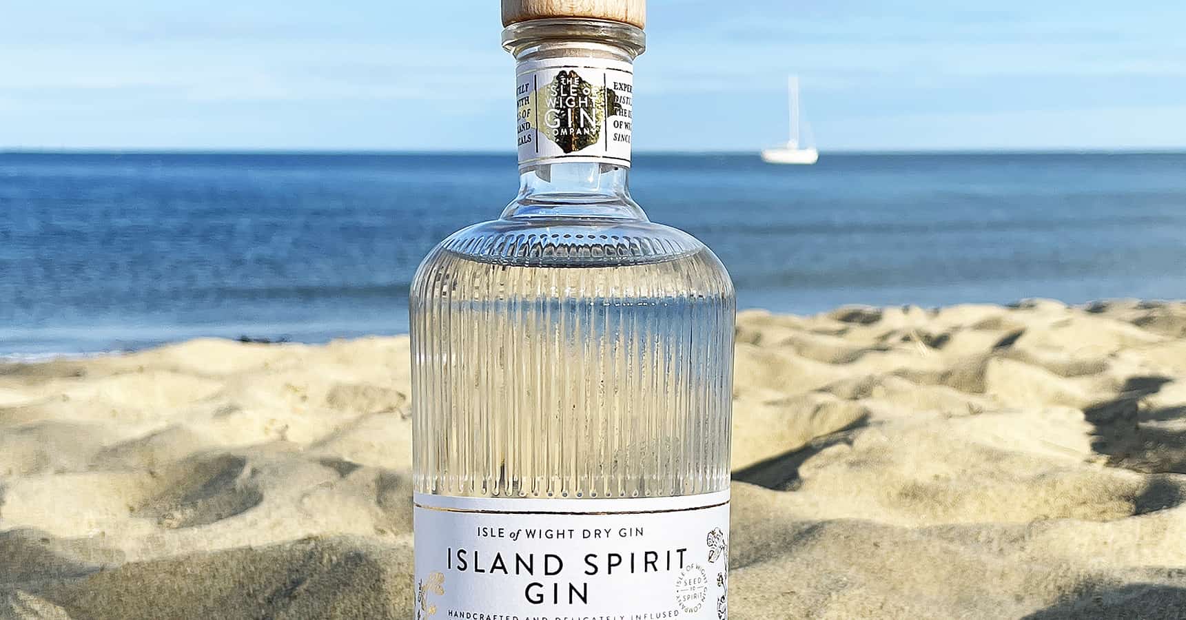 Isle of Wight gin bottle on the beach with sea in the background