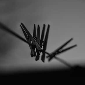 black and white image of clothes pegs on a washing line