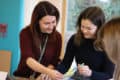 Women looking at paperwork, whilst smiling