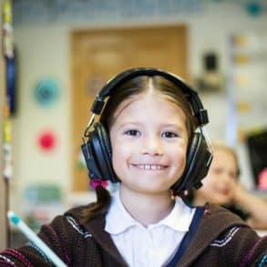 Girl in classroom with headphones on