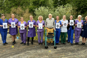 Members of mountbatten staff holding cards showing Walk the Wight fundraising Milestone