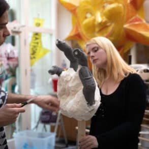 arnival artists and costume designers Joel Lines and Kira Lacey working on the hand of the puppet.