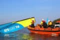 RNLI volunteers in rib rescuing people on a catamaran - UKSA