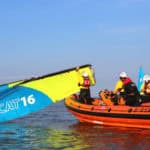 RNLI volunteers in rib rescuing people on a catamaran - UKSA