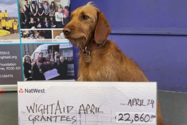 WightAid's canine mascot, Mavis, with the May 2024 cheque