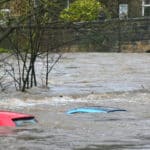 cars submerged at rise of river due to extraordinary rainfall and river bursting its banks