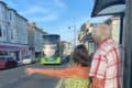 two older people flagging down a bus in Sandown