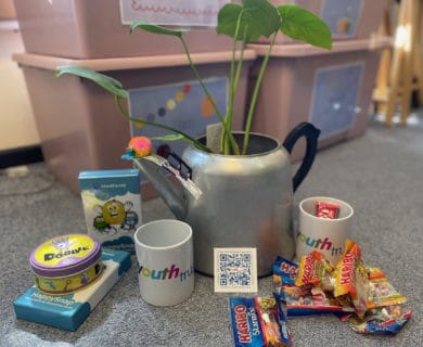 Teapot with plant in it, games and sweets