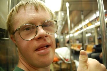 Happy lad with downs syndrome in on a train by saucysalad