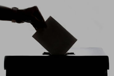 Person putting voting slip in ballot box