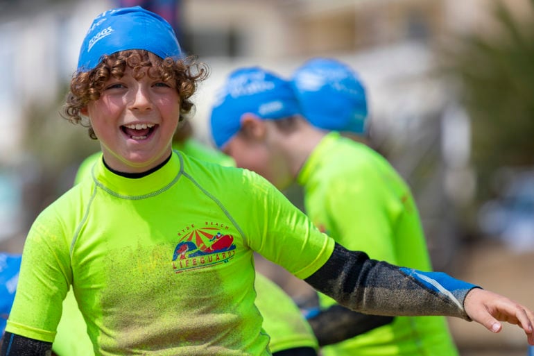 Children on the beach being taught about sea safety