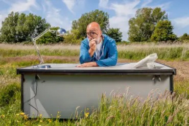 Ian Boyd sitting at a desk in the middle of a meadow