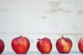 row of red apples on a school desk