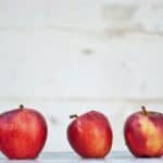 row of red apples on a school desk