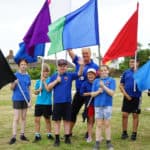 Children and Teachers holding flags at the PEACH Games