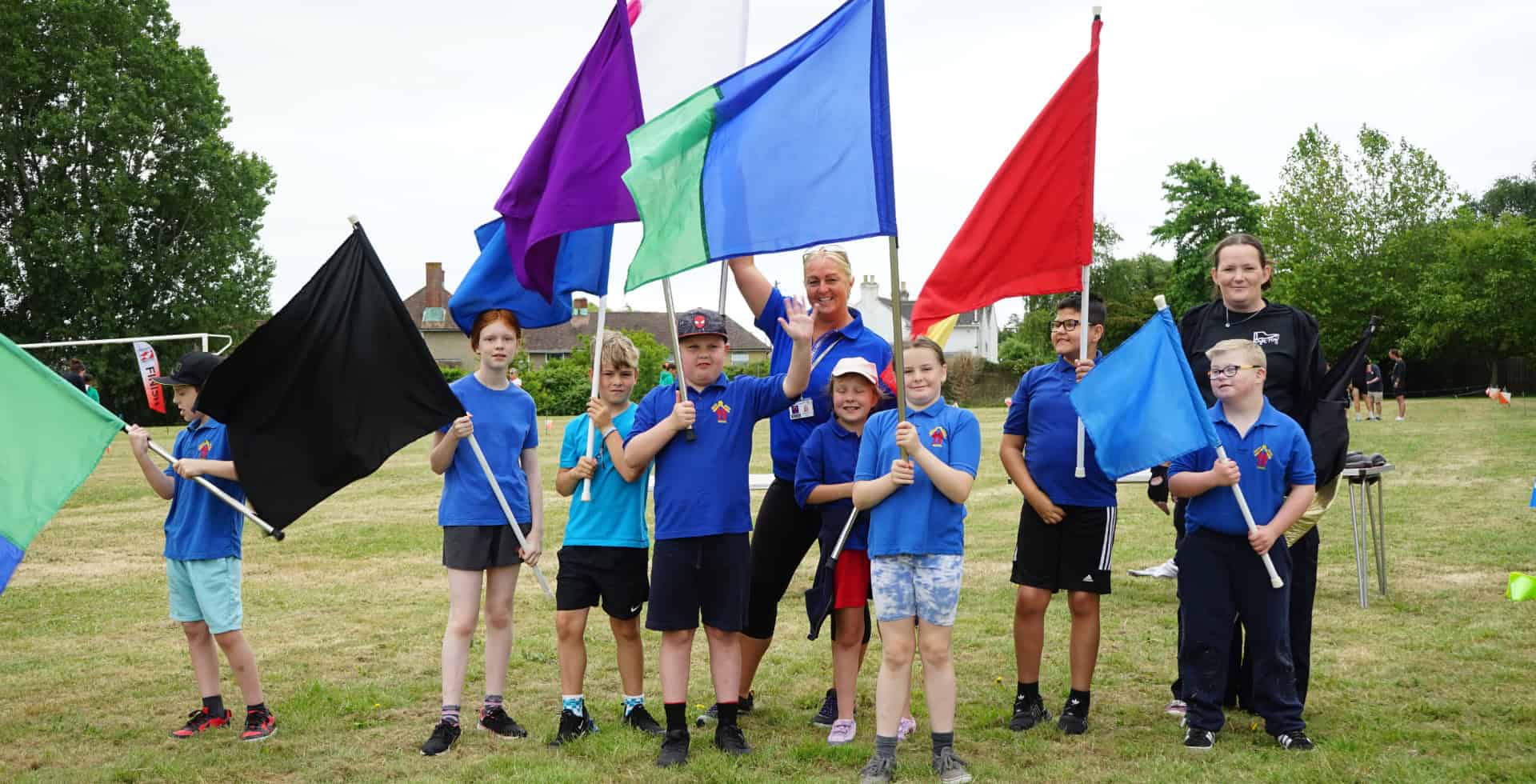 Children and Teachers holding flags at the PEACH Games