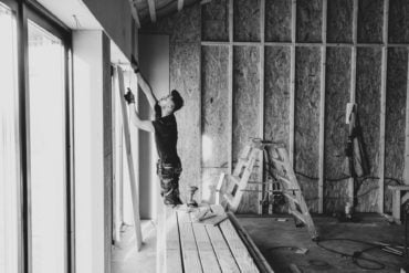 Workman fitting windows in a new house build