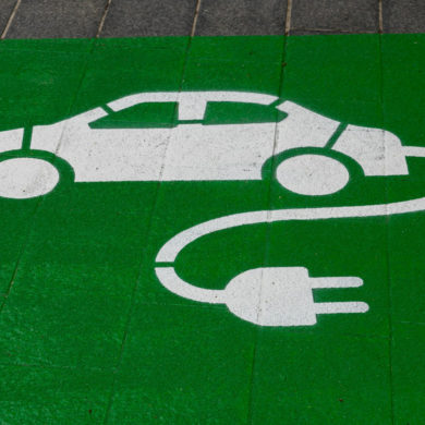 green paint on pavement with electric car symbol