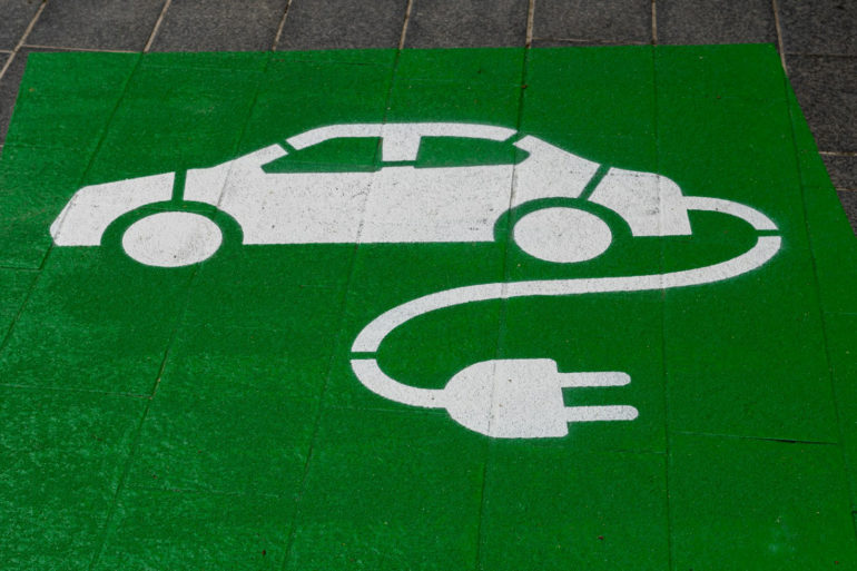 green paint on pavement with electric car symbol