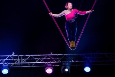 revel puck circus - woman on a high swing
