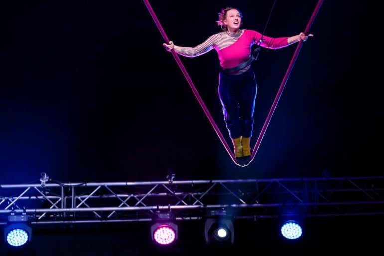 revel puck circus - woman on a high swing