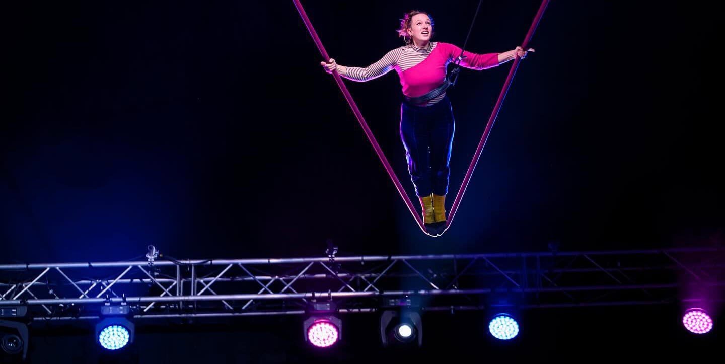 revel puck circus - woman on a high swing