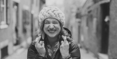 woman crossing fingers on both her hands - black and white image