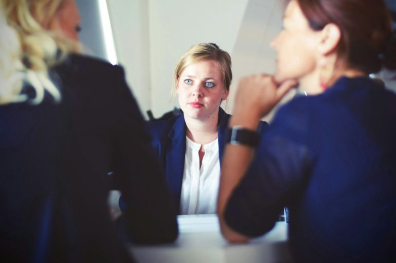 women in suits at table talking