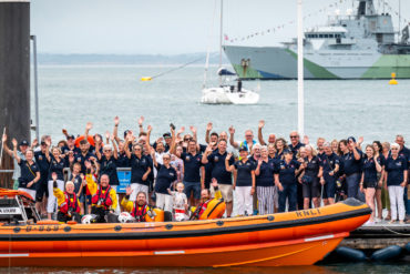 Cowes RNLI volunteers, friends and family wave to the camera alongside Atlantic 85 Lifeboat, Sheena Louise