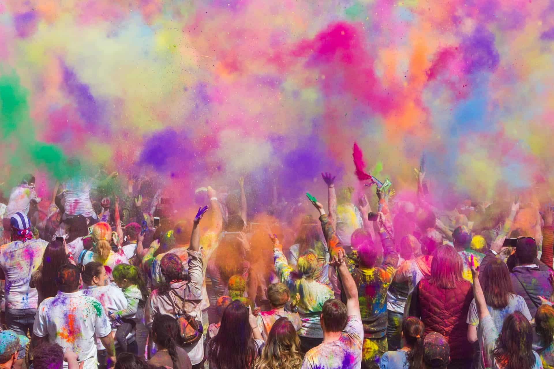 Crowd of people covered on coloured dust