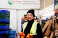 Woman working in Fareshare depot holding vegetables