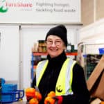 Woman working in Fareshare depot holding vegetables