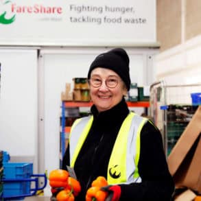 Woman working in Fareshare depot holding vegetables