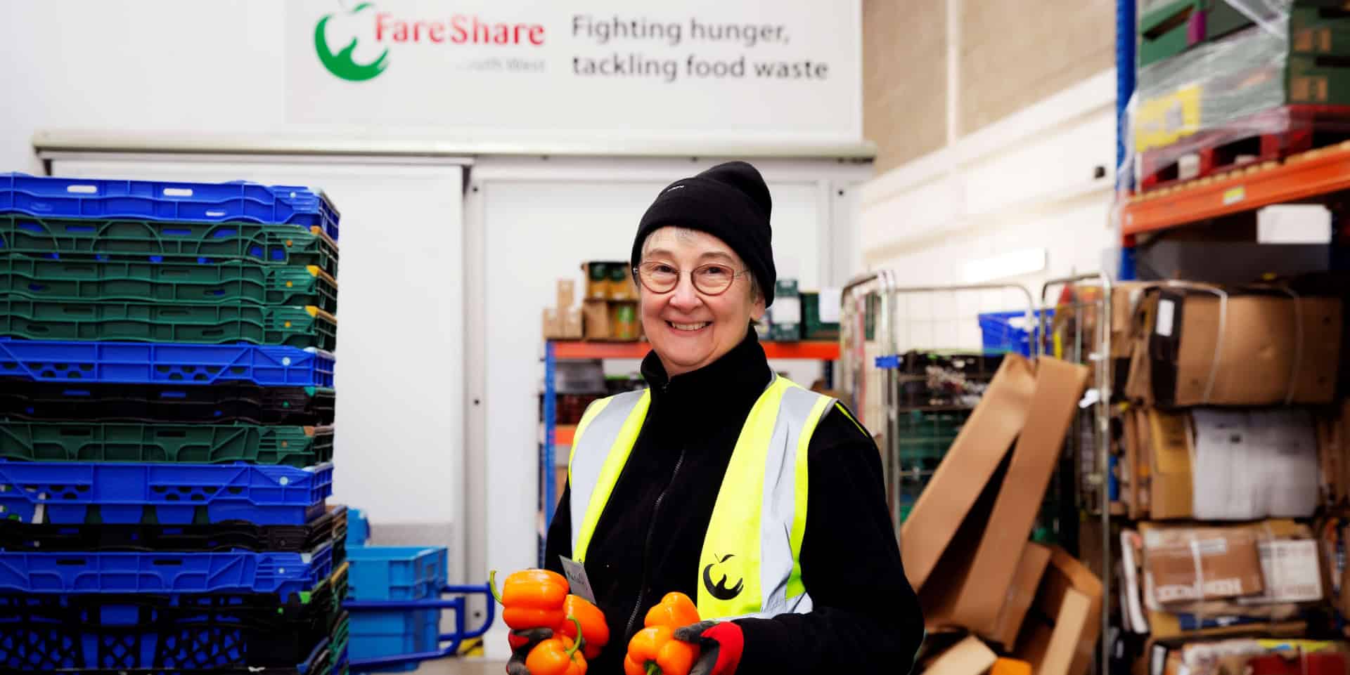 Woman working in Fareshare depot holding vegetables