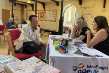 Resident sat with age uk advisors in St Catherine's Church