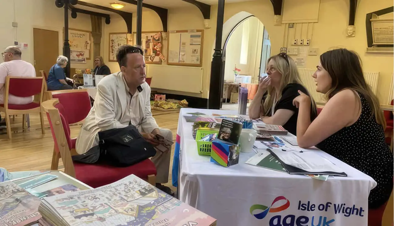 Resident sat with age uk advisors in St Catherine's Church