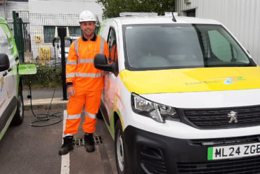 Aiden Reeves, District Steward standing by electric vehicles charging