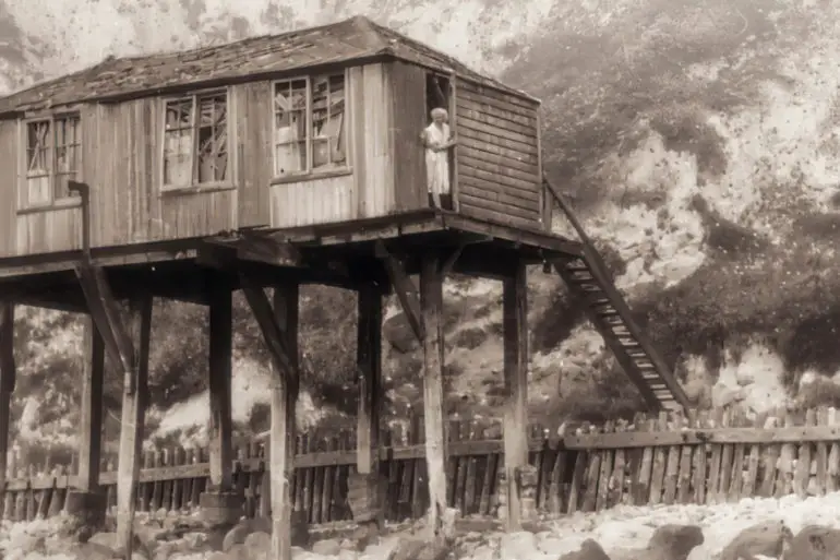 Olivia Parkes standing outside her hut photo from Michael Freeman and Bob Trwobridge's Book