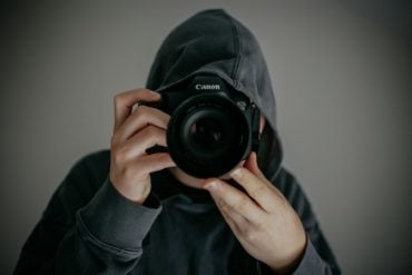 Person pointing a camera at the camera