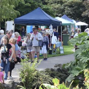 People walking through the park on Ventnor Day, with stall in the background