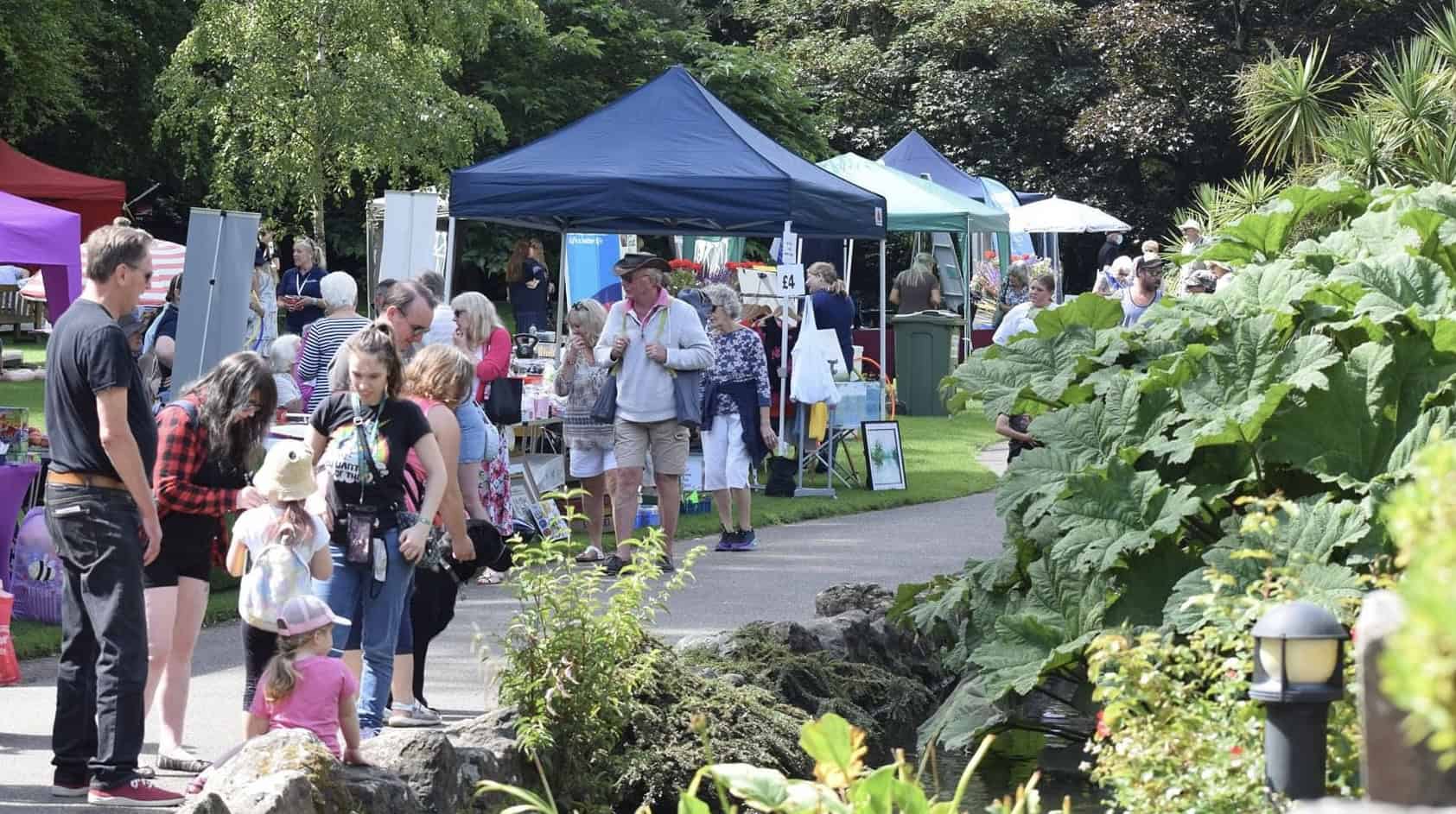 People walking through the park on Ventnor Day, with stall in the background