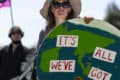 Woman at Extinction Rebellion protest holding large cut out of the earth