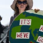 Woman at Extinction Rebellion protest holding large cut out of the earth