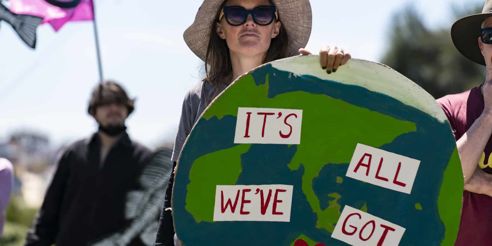 Woman at Extinction Rebellion protest holding large cut out of the earth