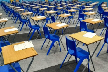 desks and chairs set up in a hall ready for exams