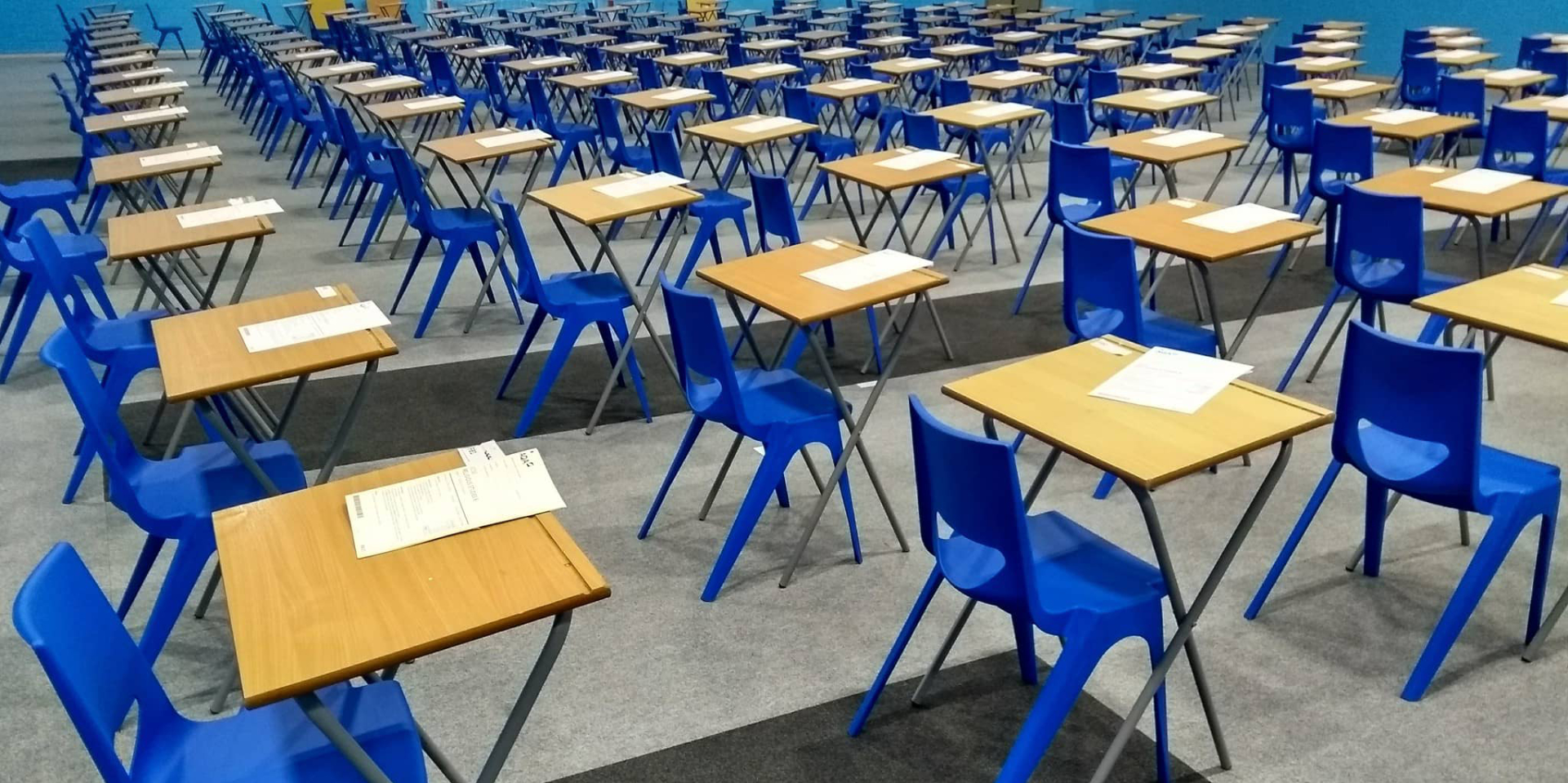 desks and chairs set up in a hall ready for exams