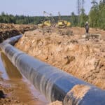 Gas pipeline being installed across countryside and through woodland