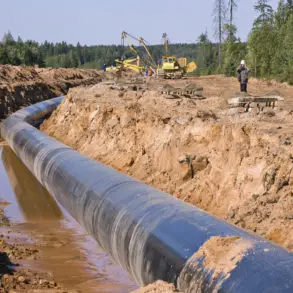 Gas pipeline being installed across countryside and through woodland