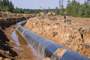 Gas pipeline being installed across countryside and through woodland