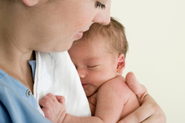 Mother holding her baby close to her chest